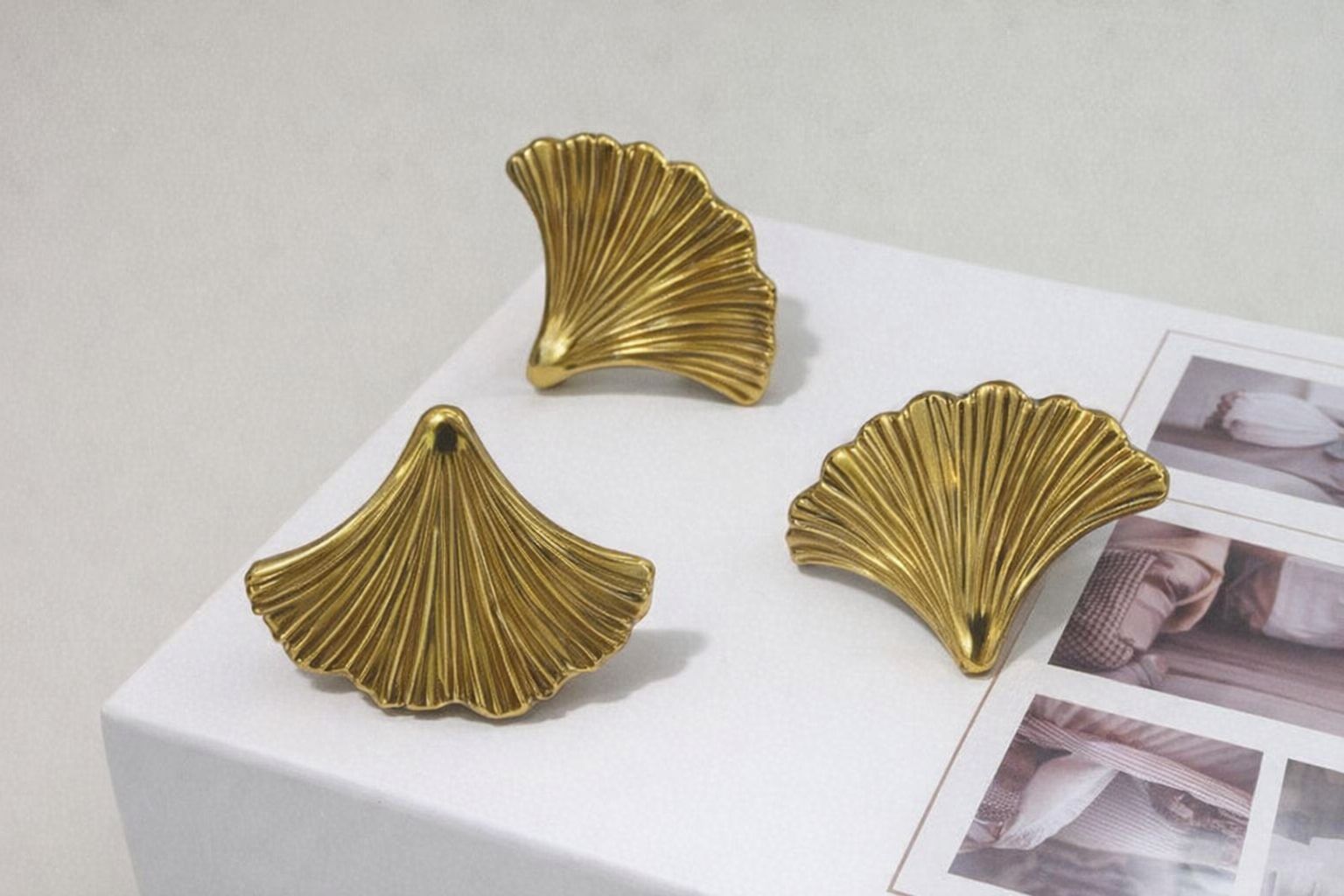 Drie goudkleurige handgrepen in de vorm van ginkgo-bladeren voor een cafékeuken.