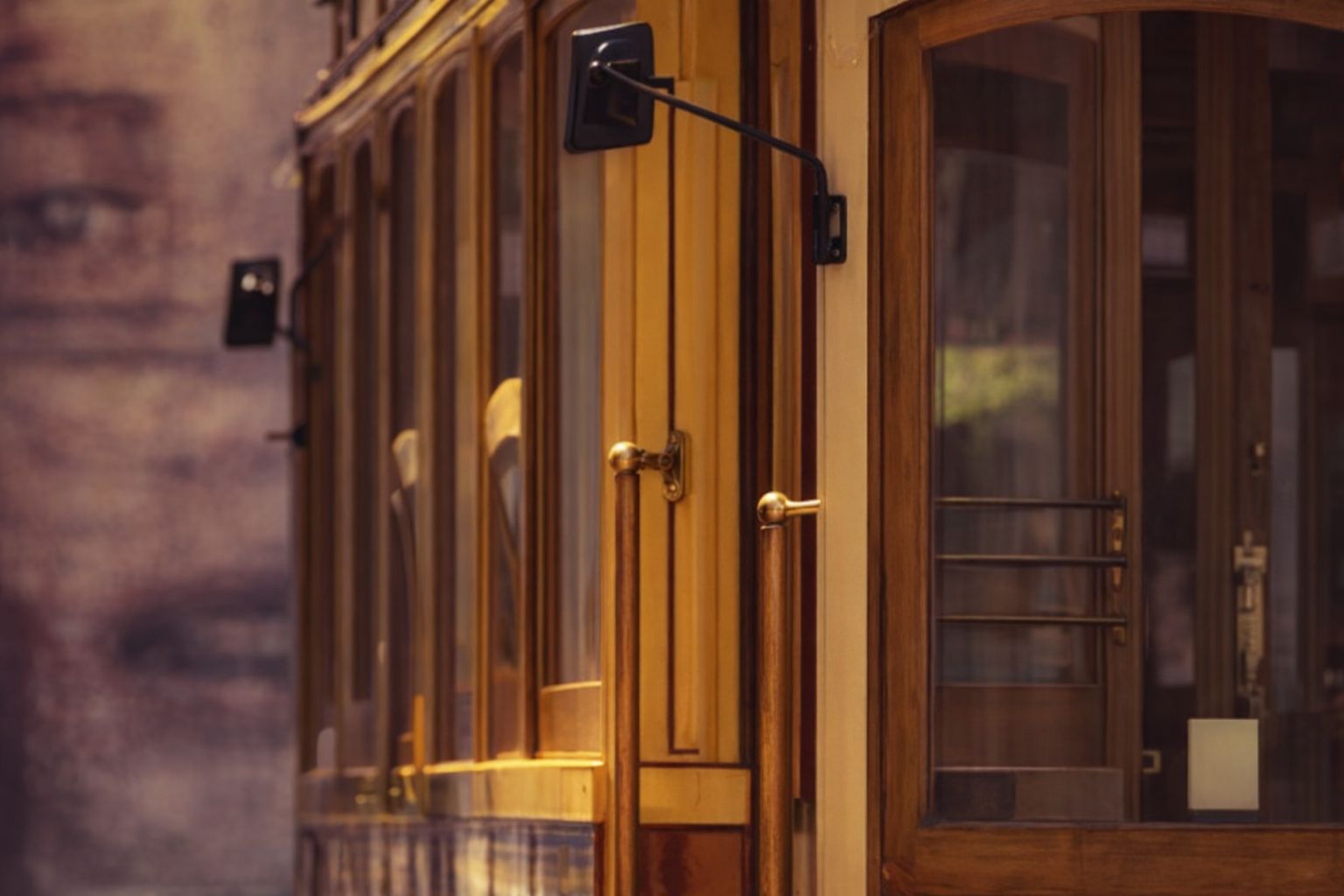 Detail van een klassiek houten tramstel met koperen knoppen en handgrepen.